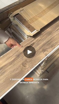 a person standing in front of a wooden flooring machine with wood planks on it