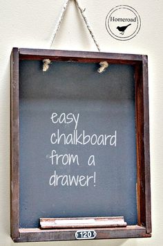 an easy chalkboard from a drawer is hung on the wall with twine rope