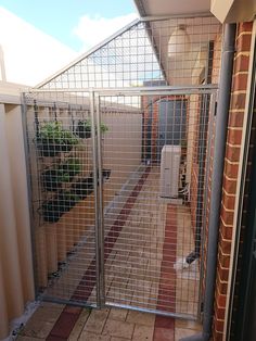 a gated in area with a brick wall and tiled floor next to a building