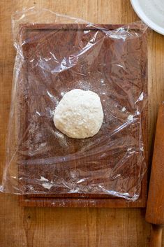 a piece of bread sitting on top of a wooden cutting board