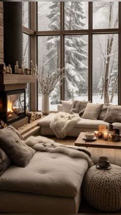 a living room filled with lots of furniture next to a fire place and large windows