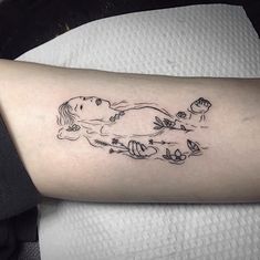 a woman's arm with a tattoo on it that has an image of a dog and flowers