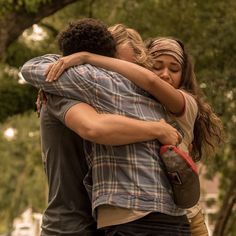 two people hugging each other in the street