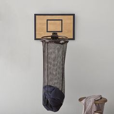 a basketball hoop hanging on the wall next to a hat rack with a baseball cap in it