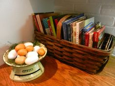 a basket filled with eggs sitting on top of a wooden table next to a bookshelf