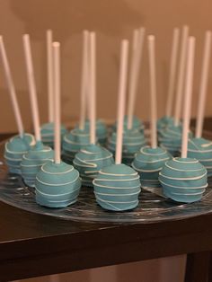 there are many blue and white cake pops on the plate with toothpicks in them