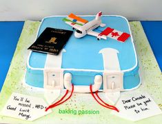 a cake that is shaped like a suitcase with an airplane on top and some writing on the side