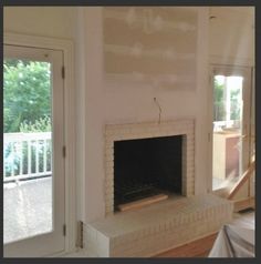 an empty living room with a fireplace and sliding glass doors