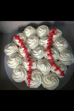 white frosted cupcakes with red bows on top are arranged in a circle