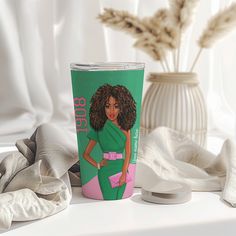 there is a cup with a woman on it next to a vase and some flowers