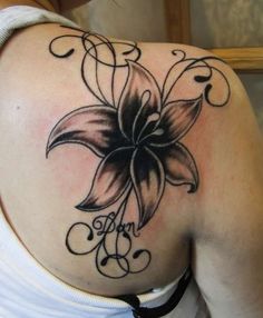 a woman's back with a flower tattoo on it