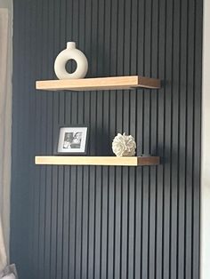 two wooden shelves are on the wall in this room