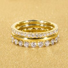 three gold rings with diamonds on a golden background