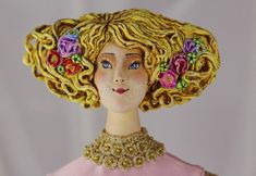 a close up of a statue of a woman with flowers in her hair wearing a pink dress