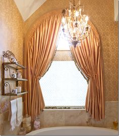 a bath room with a tub and a chandelier hanging from it's ceiling