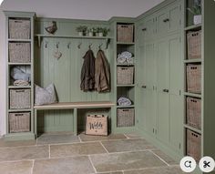 a mud room with green cabinets and baskets