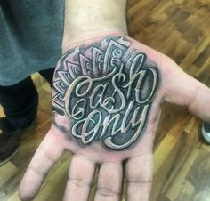 a man's hand with the words cash and envy tattooed on his left palm