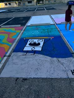 a person is standing in the middle of a parking lot with chalk drawings on it