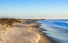 a sandy beach with waves coming in to shore