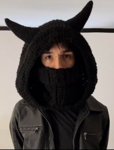 a man wearing a black knitted hood with horns