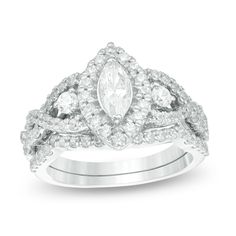 a white gold ring set with two pear shaped diamonds on each band and an oval diamond in the center