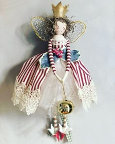 a doll hanging from the side of a wall next to a bell ornament