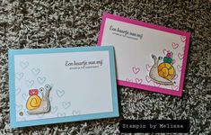 two cards with snails on them sitting next to each other in front of a pile of carpet