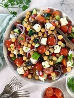 a salad with tomatoes, cucumbers, olives, and feta cheese