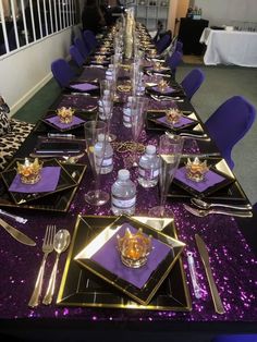 a long table with purple sequins and gold place settings on it, along with silverware