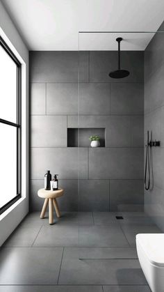 a modern bathroom with white walls and grey flooring, along with a large window