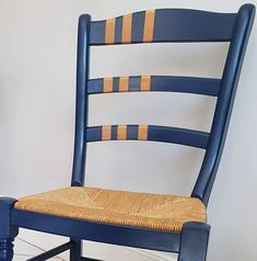 a blue chair with a woven seat pad on the bottom and back, in front of a white wall