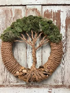 a wreath made out of rope with a tree on top and nuts in the middle