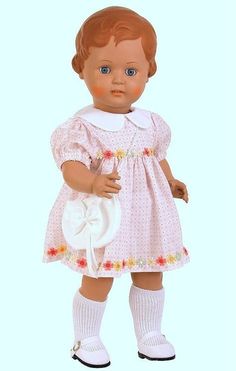 a doll is wearing a pink dress and white shoes