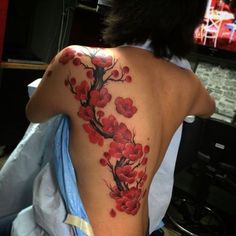 the back of a woman's shoulder with red flowers on it