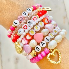 a close up of a person's arm wearing bracelets with charms and beads