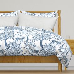 a bed with blue and white bedspread, pillows and pillow cases on it