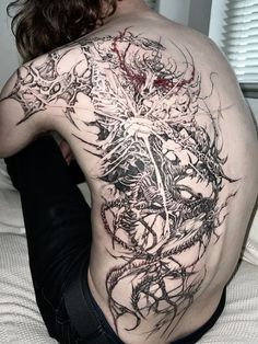 the back of a man with tattoos on his body