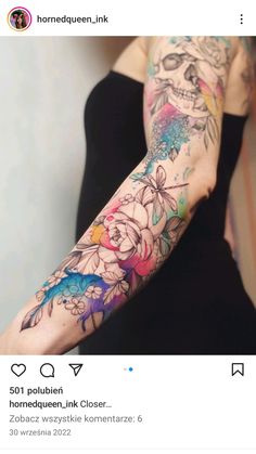 a woman's arm with flowers and skulls on it, in the middle of her arm