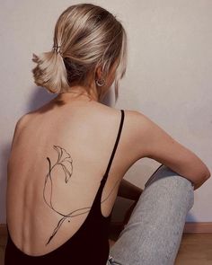 a woman with a flower tattoo on her back