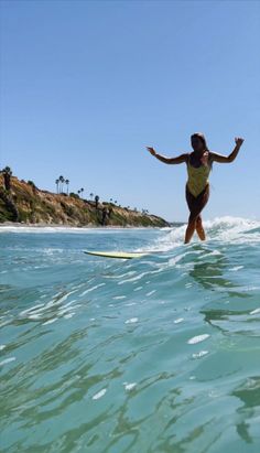 a woman riding a surfboard on top of a wave in the middle of the ocean