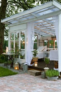 a white gazebo sitting next to a lush green park