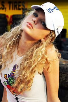 a woman with long blonde hair wearing a white hat