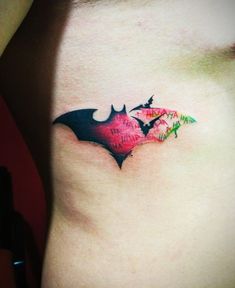 a tattoo on the side of a woman's stomach shows two bats flying in opposite directions