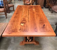 a large wooden table sitting inside of a room next to other tables and chairs on the floor