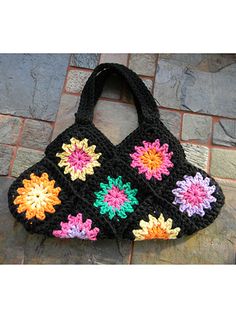 a crocheted black purse with multicolored flowers on the front and sides