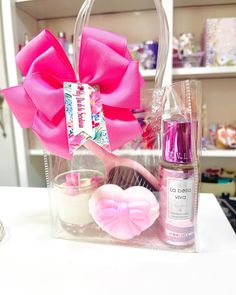 a pink bow on top of a bag next to other items in a glass container