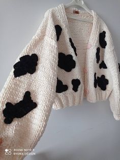 a white sweater with black spots on it