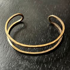 This hammered brass cuff bracelet is basically the simplified outline of my solid cuff bracelet's profile, which is a great alternative that will match all of your 永 rings, earrings and necklaces! It is flexible enough so that you can gently open it wider and squeeze it tighter as needed- it should fit comfortably on most wrists! I love that all four sides/faces are flat, (versus rounded) which, when hammered, provides some great texture and gives this simple outline a little more visual weight Minimalist Adjustable Hammered Cuff Bracelet, Minimalist Hand Forged Brass Bracelets, Modern Hand Forged Brass Bracelets, Minimalist Adjustable Brass Cuff Bracelet, Adjustable Hammered Bronze Cuff Bracelet, Gold Hammered Copper Cuff Bracelet, Adjustable Hand Forged Bronze Cuff Bracelet, Modern Adjustable Hand Forged Bangle, Brass Cuff Bracelet