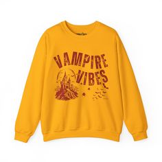 Sink your teeth into Halloween fashion with the Eddy and Rita Women's Heavy Crewneck Sweatshirt featuring the phrase "Vampire Vibes" in a spooky, stylish design. This heavyweight sweatshirt provides maximum warmth and comfort, making it perfect for those crisp autumn nights. With its relaxed fit, this sweatshirt is ideal for layering over your favorite Halloween ensemble or wearing solo for a cozy night in. Whether you're hitting a Halloween party, trick-or-treating, or just enjoying the season, Punk Halloween Sweatshirt With Graphic Print, Punk Style Halloween Sweatshirt With Graphic Print, Punk Halloween Sweatshirt With Letter Print, Gothic Letter Print Tops For Fall, Gothic Halloween Graphic Sweatshirt, Vampire Vibes, Crisp Autumn, Halloween Graphic, Autumn Night