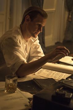 a man sitting at a desk working on papers